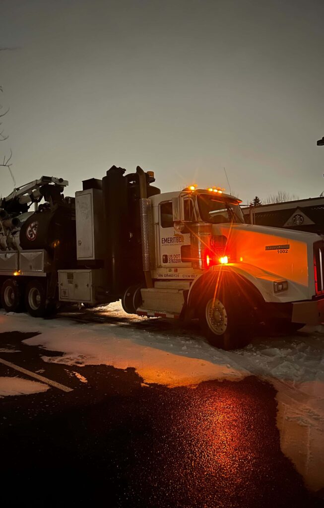 Hydro excavation equipment operating under floodlights during a nighttime project. Workers in high-visibility safety gear demonstrate the method's around-the-clock capability, ensuring project timelines are met with precision and safety in various lighting conditions.